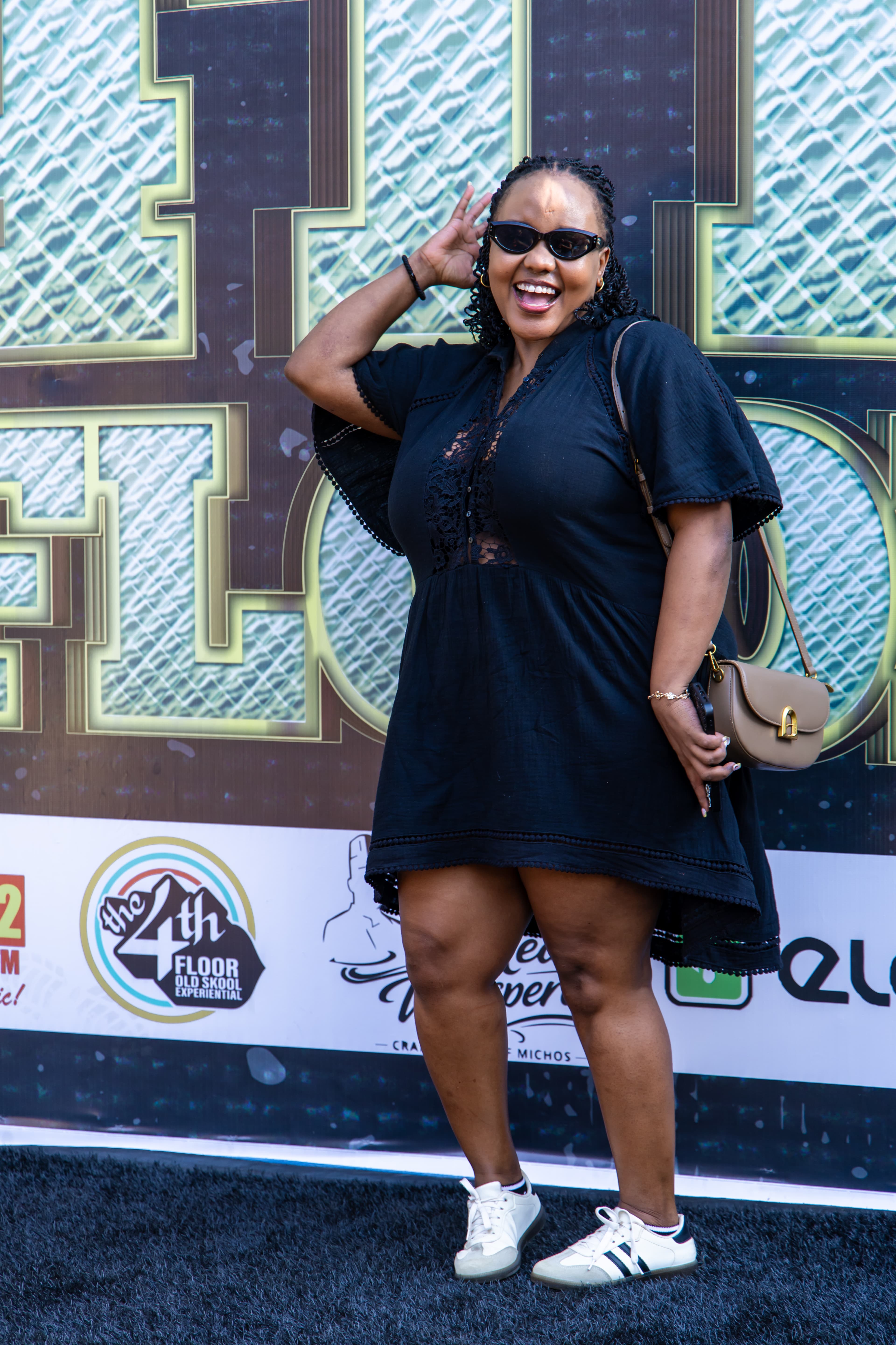 A guest posing beside the 4th Floor event backdrop