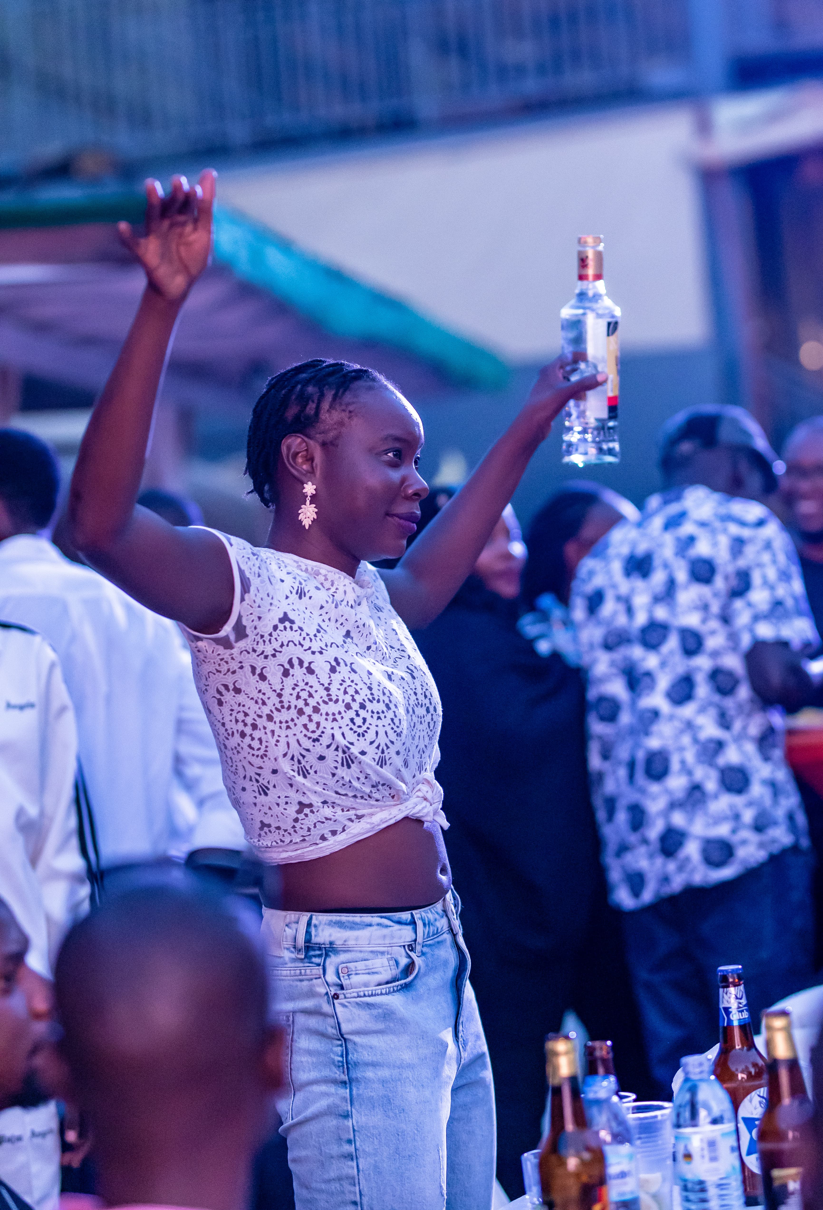 A guest dancing with a drink raised in celebration